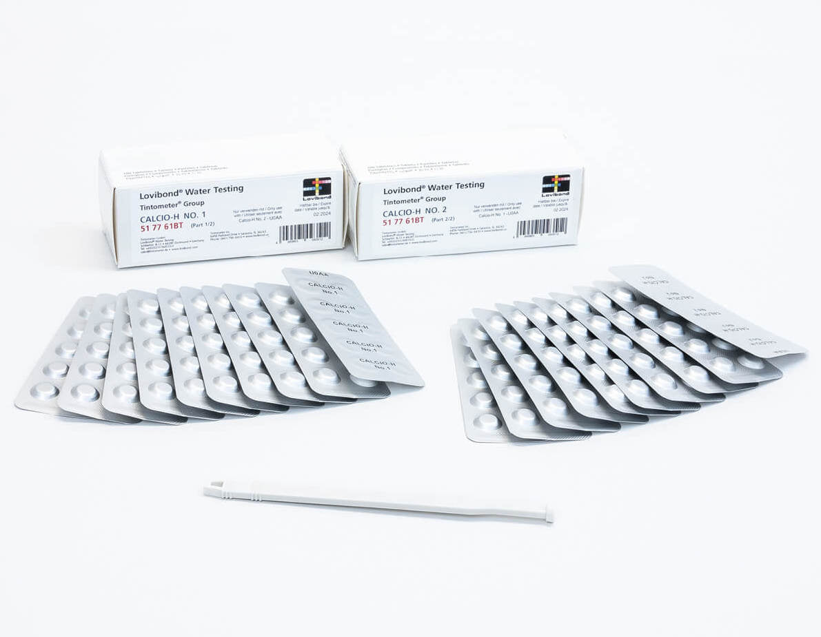 Pastiglie reagenti Lovibond per analisi durezza acqua, confezioni e blister su sfondo bianco.