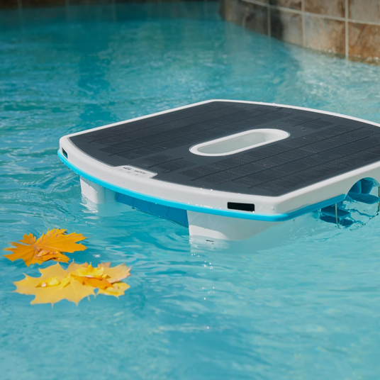 Dispositivo galleggiante quadrato in piscina con foglie gialle sull'acqua.