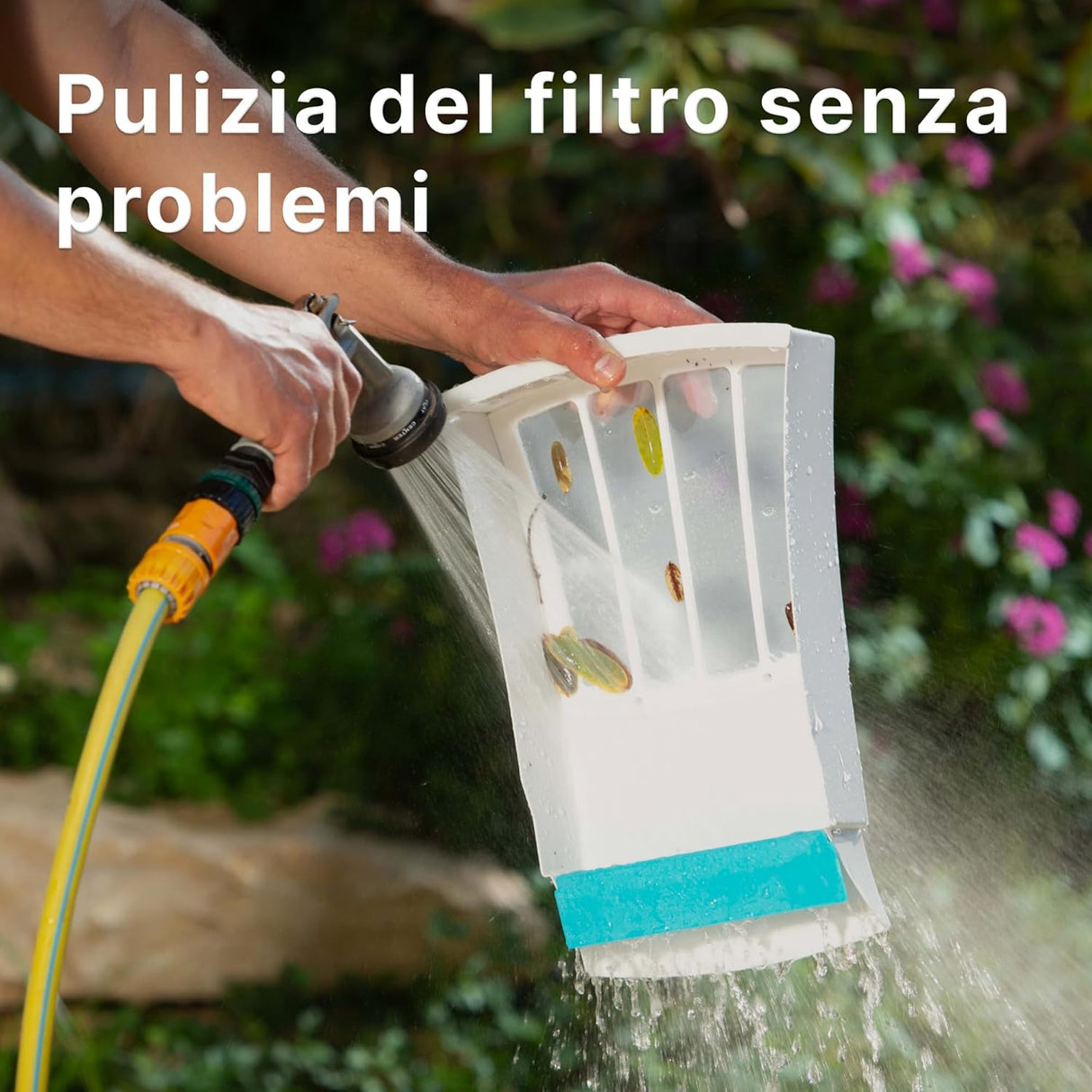 Filtro del robot Dolphin Skimmi pulito con tubo da giardino, foglie rimosse, sfondo di piante fiorite.