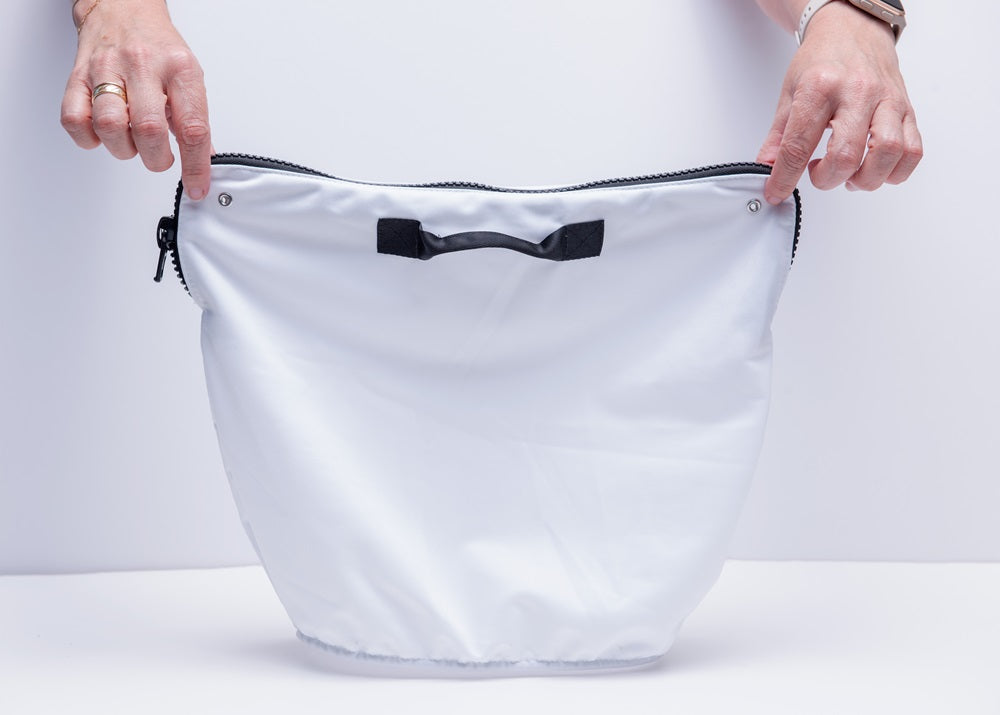 Sacco filtro ultra fine per robot piscina, tenuto da due mani, bianco con zip nera.