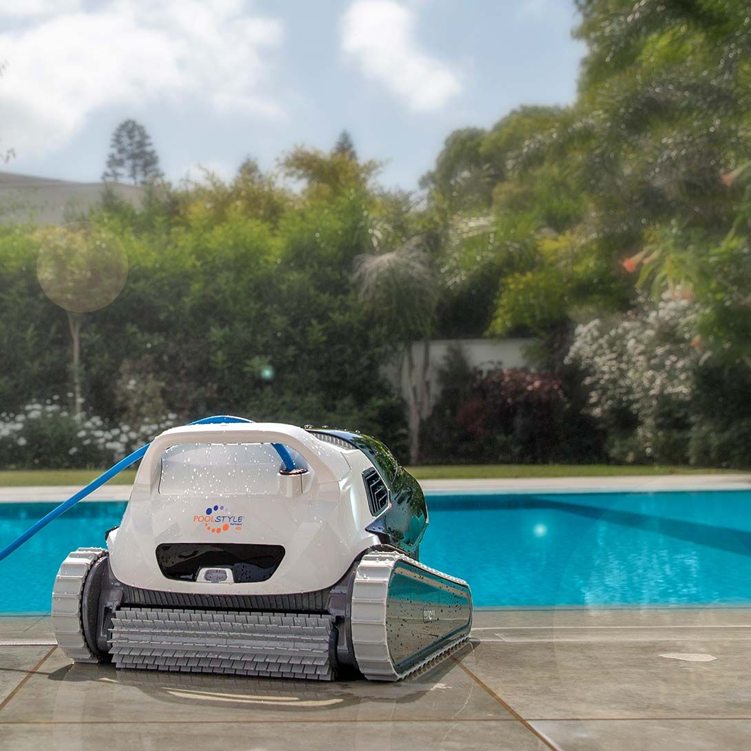 Robot pulitore per piscina su bordo vasca, con sfondo di piscina e giardino verde.