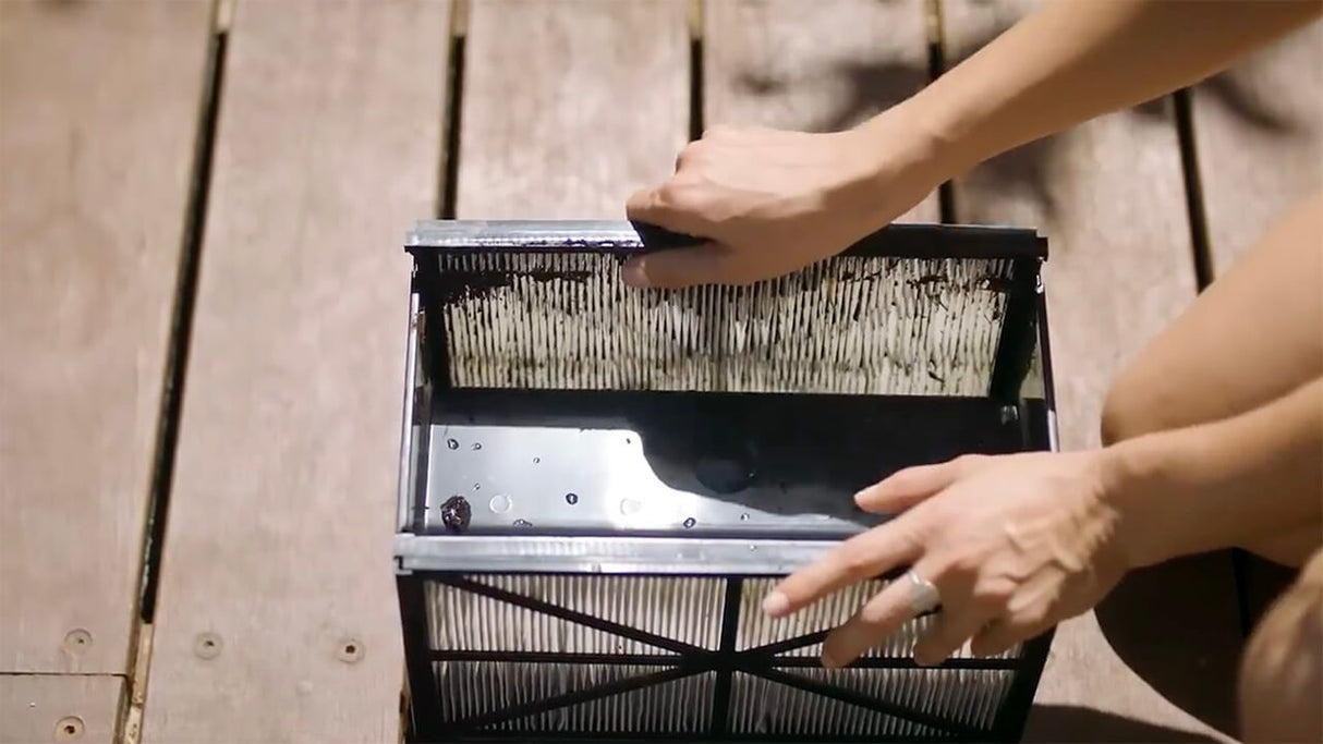 Filtro del robot Hayward TigerShark XL QC pulito a mano su una superficie di legno.