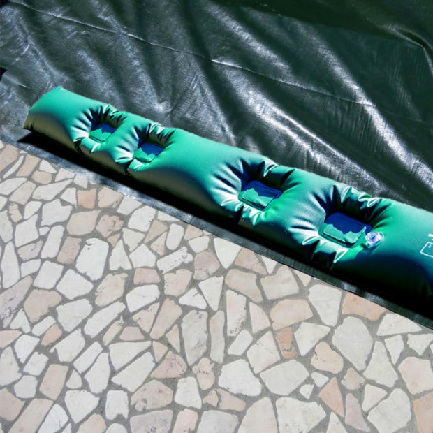 Tubolare salsicciotto in PVC rinforzato su bordo piscina con telo di copertura verde scuro.