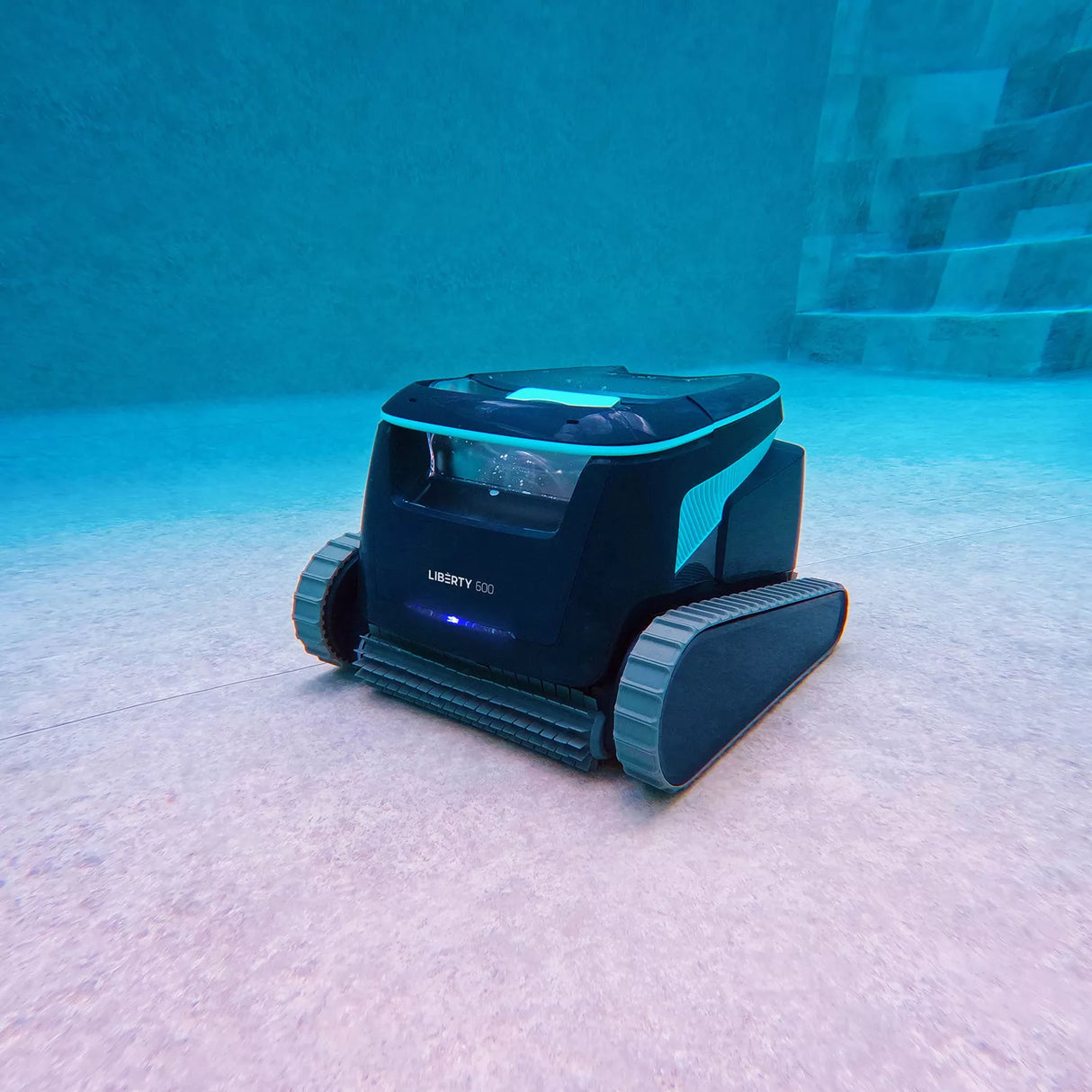 Robot piscina Dolphin Liberty 600i in azione sul fondo, vicino a una scala sommersa.