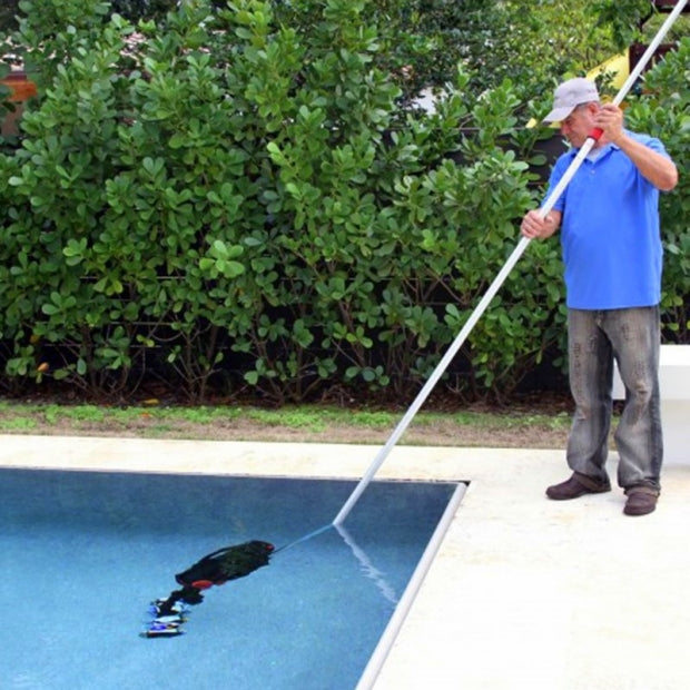 Uomo utilizza WaterTech Pool Blaster Precision 2.0 per pulire il fondo di una piscina.