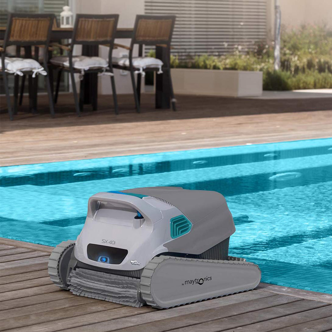 Robot piscina Dolphin SX 40i a bordo piscina in legno, pronto per pulizia automatica.
