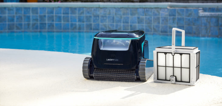 Robot piscina Dolphin Liberty 600i sul bordo piscina con cassetto filtro accanto.