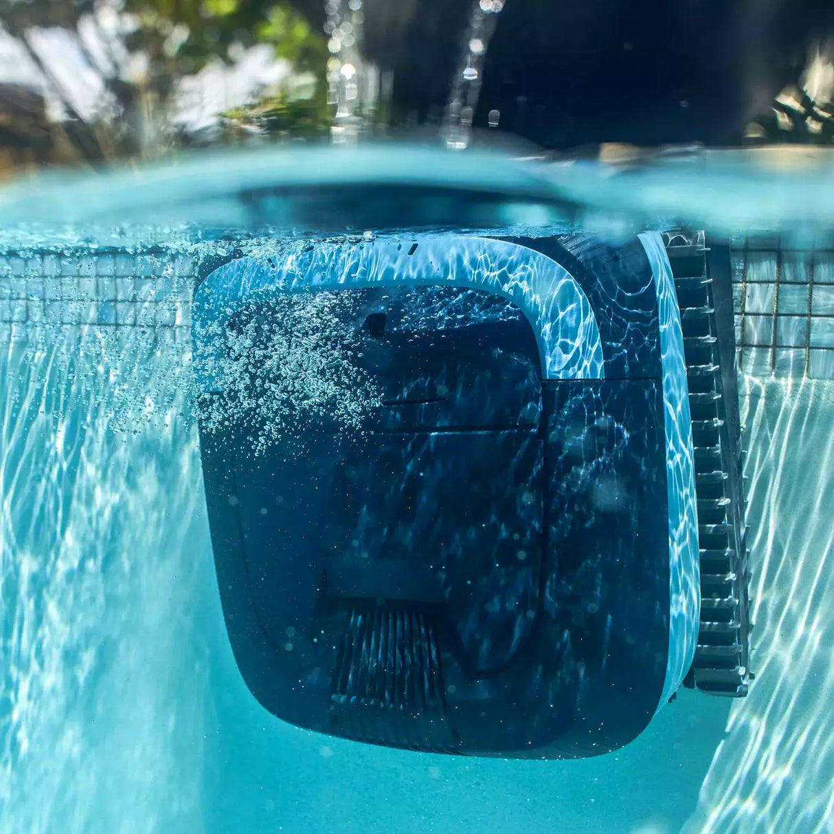 Robot piscina Dolphin Eon 100i in azione sott'acqua, con getto e bolle visibili.
