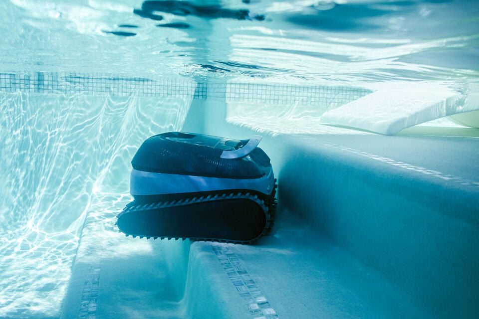Robot piscina Dolphin Eon 100i cordless in azione su gradini sommersi di una piscina.