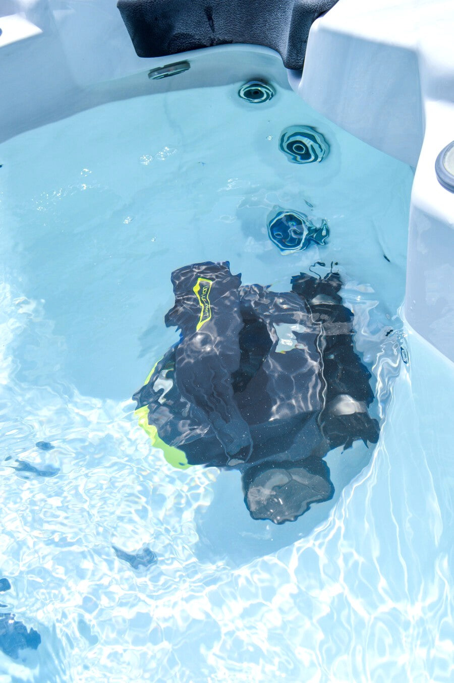 Robot pulitore Zodiac SPABOT OS 0800 in azione, immerso in una vasca idromassaggio.