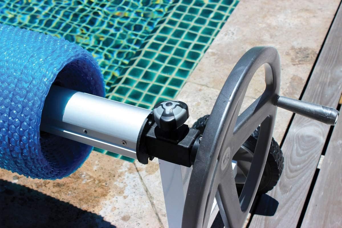 Rullo avvolgitore telescopico Kokido KALU con telo blu vicino al bordo piscina.