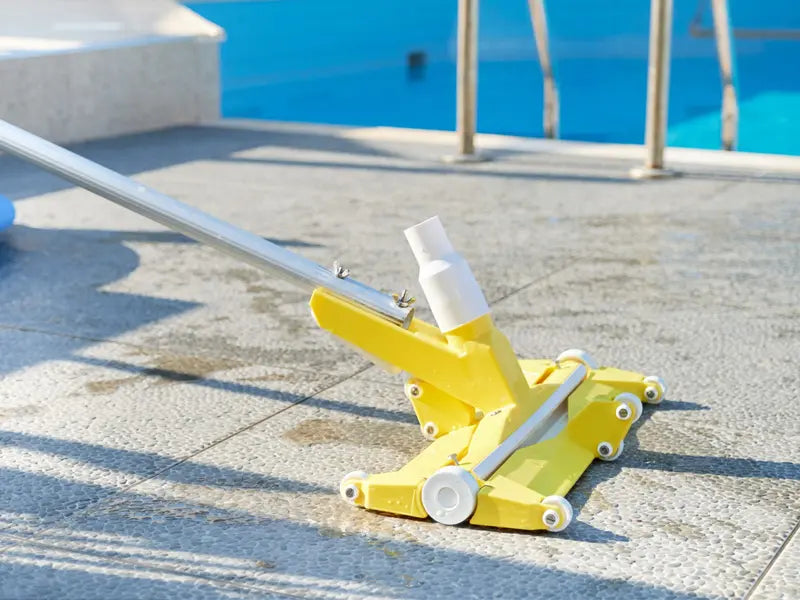 Aspirafango Fairlocks giallo su bordo piscina, attrezzo per pulizia manuale.