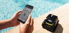 Smartphone controlla Zodiac Freedom OF 42 iQ Gyro, robot piscina sul bordo vicino all'acqua.