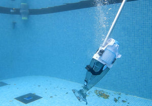 Aspiratore BWT PK GIANT in azione sul fondo di una piscina, raccoglie foglie e detriti.