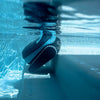 Robot piscina Dolphin Eon 100i in azione sott'acqua su gradino piscina.