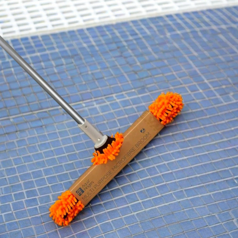 Spazzola in microfibra arancione per piscine, su pavimento piastrellato blu.